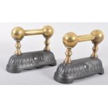 A pair of Victorian cast iron and brass fire dogs, with twin brass ball finials,
