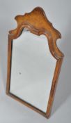 A walnut arched rectangular George II style dressing-table mirror, within cushion-moulded frame,