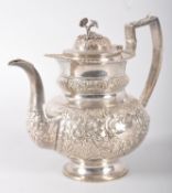 An Irish silver coffee pot, of heavily repousse floral and scroll decorated oval form,