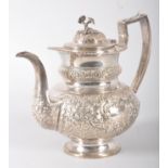 An Irish silver coffee pot, of heavily repousse floral and scroll decorated oval form,