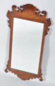 An 18th century George IV style wall hanging mahogany mirror having shaped and scrolled fretwork