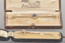 A 15ct gold (stamped) bar brooch set with an oval faceted cut aquamarine