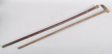 Two malacca walking canes, the first with initialled silver mounts, decorated with repousse scrolls,
