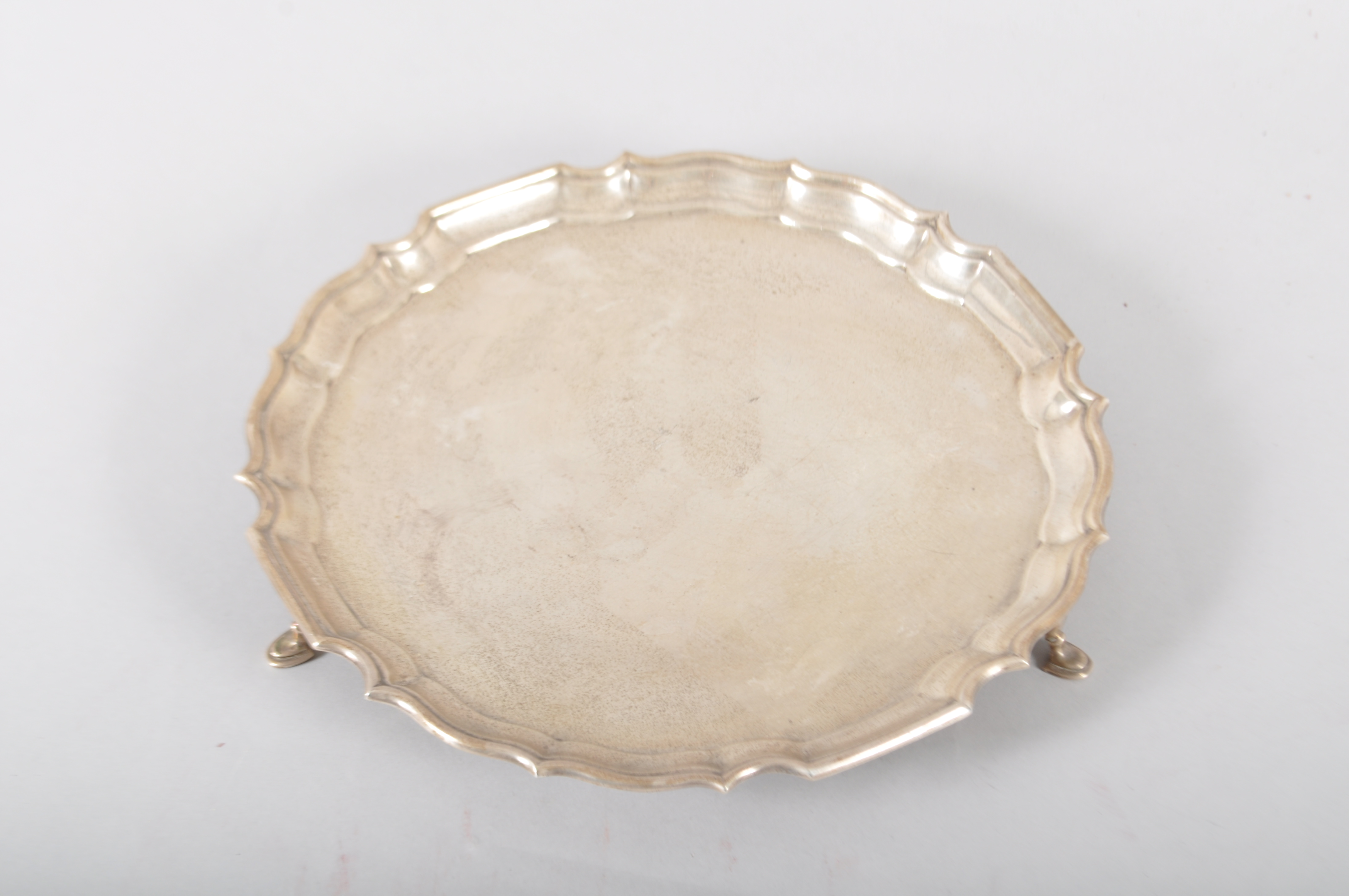 A silver salver, of plain form with Chipppendale border, raised on three pad feet, Sheffield 1966,