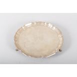 A silver salver, of plain form with Chipppendale border, raised on three pad feet, Sheffield 1966,