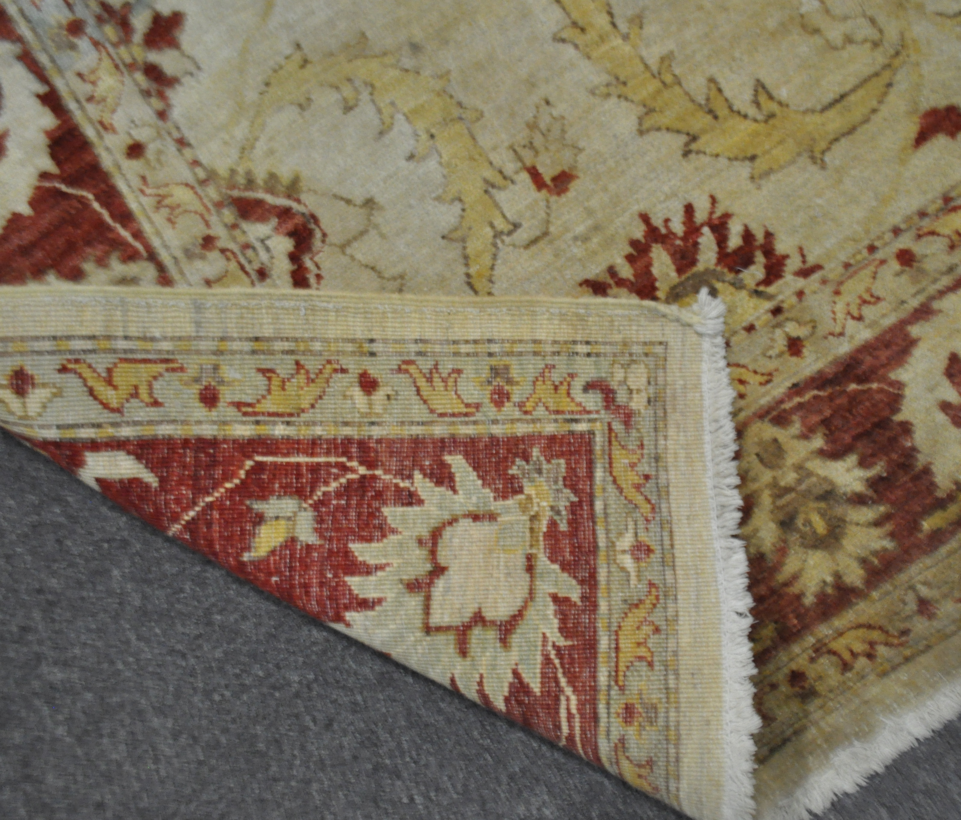 A wool carpet with beige ground woven with scrolling leaves and flowerheads in yellow, red and blue, - Image 3 of 3