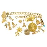 A yellow metal curb link bracelet having four fixed charms and fourteen assorted loose charms.