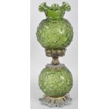 A Victorian style green-tinted press-moulded oil lamp, the well and shade moulded with flowers,