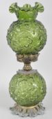 A Victorian style green-tinted press-moulded oil lamp, the well and shade moulded with flowers,