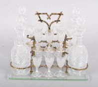 Early Victorian four bottle tantalus on stand with fourteen glasses,