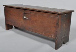 A late 17th century oak coffer, the single plank top with pin hinges,