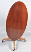 A 19th century mahogany oval tilt top table, on turned pedestal and splayed legs with brass casters,