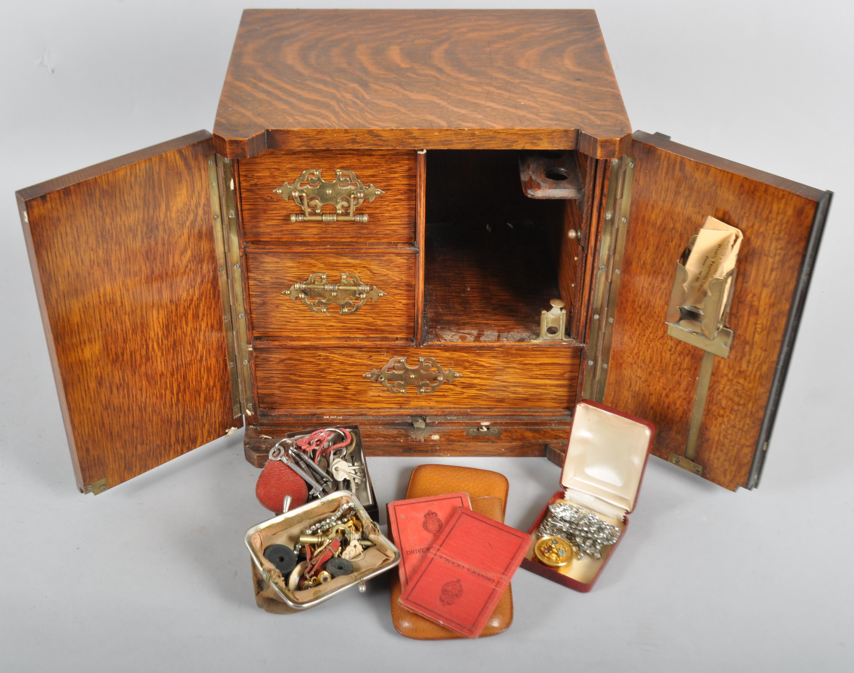 An oak smoker's table-top cabinet, the hinged doors revealing a cupboard,