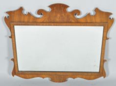 An 18th Century George IV style wall hanging mahogany mirror having fretwork decoration to top