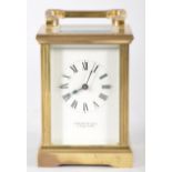 A brass cased carriage clock having a white enamel face, Roman numeral dial,
