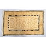 A small gold and ivory ground wool rug,