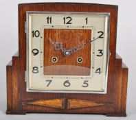 An oak cased Art Deco clock, of rectangular stepped form, striking on a gong,