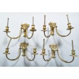 A set of four early 20th century Adams revival brass electric double wall sconces