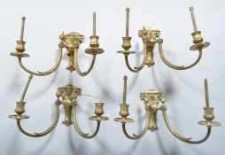 A set of four early 20th century Adams revival brass electric double wall sconces