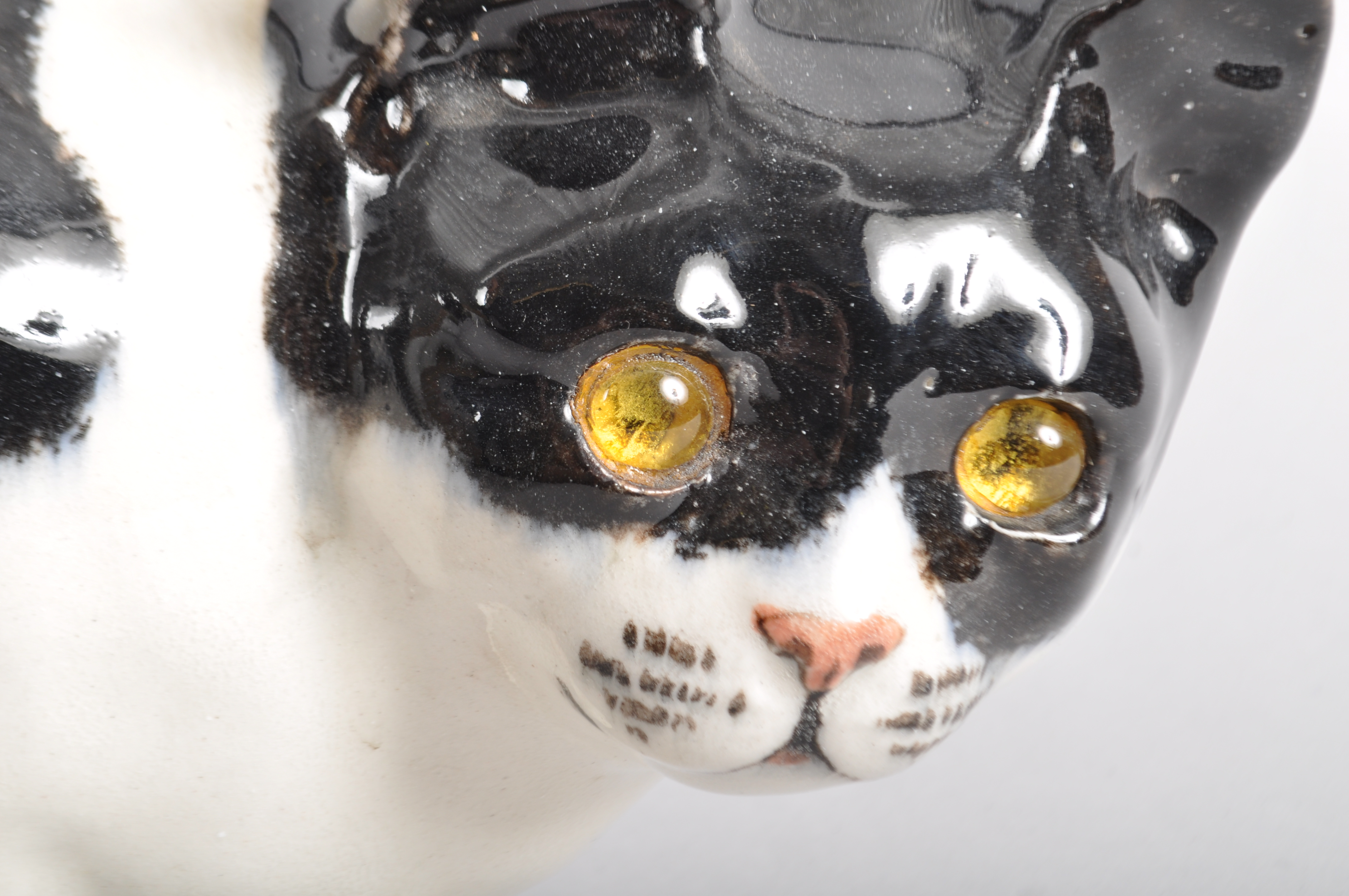 An English pottery model of a black and white cat in the Wemyss style, signed G. - Image 2 of 2