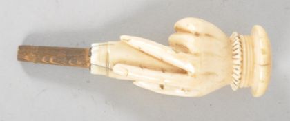 A Victorian carved ivory novelty bottle stopper, in the form of a hand holding a wooden stopper,