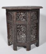 A carved Indian octagonal occasional table, of hinged panelled construction,