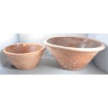 A set of two graduating terracotta dairy bowls of usual form having a salt glazed inner and