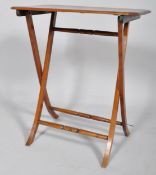 An Edwardian mahogany folding table, the canted rectangular top above hinged end supports,