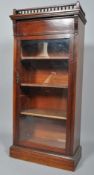 A late Victorian mahogany glazed bookcase, the balustraded top above acanthus cappings,