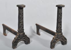 A pair of Edwardian heavy cast fire dogs with cast decoration,