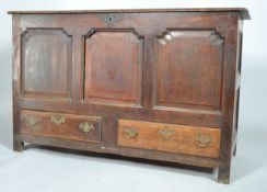 A George II oak mule chest, the hinged plank top above panelled front and sides,