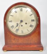 An Edwardian mahogany and inlay arch top mantle clock with carved edge, Roman numeral dial,