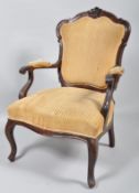 A 19th century Victorian mahogany elbow chair having carved decoration to backrest and upholstered