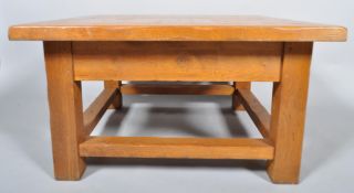 A contemporary oak square coffee table, having a flared top,