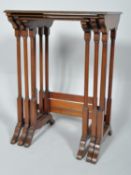 A nest of three Edwardian mahogany occasional tables, on turned corner column supports,