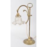 An Edwardian brass adjustable desk lamp, with frosted glass petal shaped shades, on adjustable stem,
