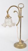 An Edwardian brass adjustable desk lamp, with frosted glass petal shaped shades, on adjustable stem,