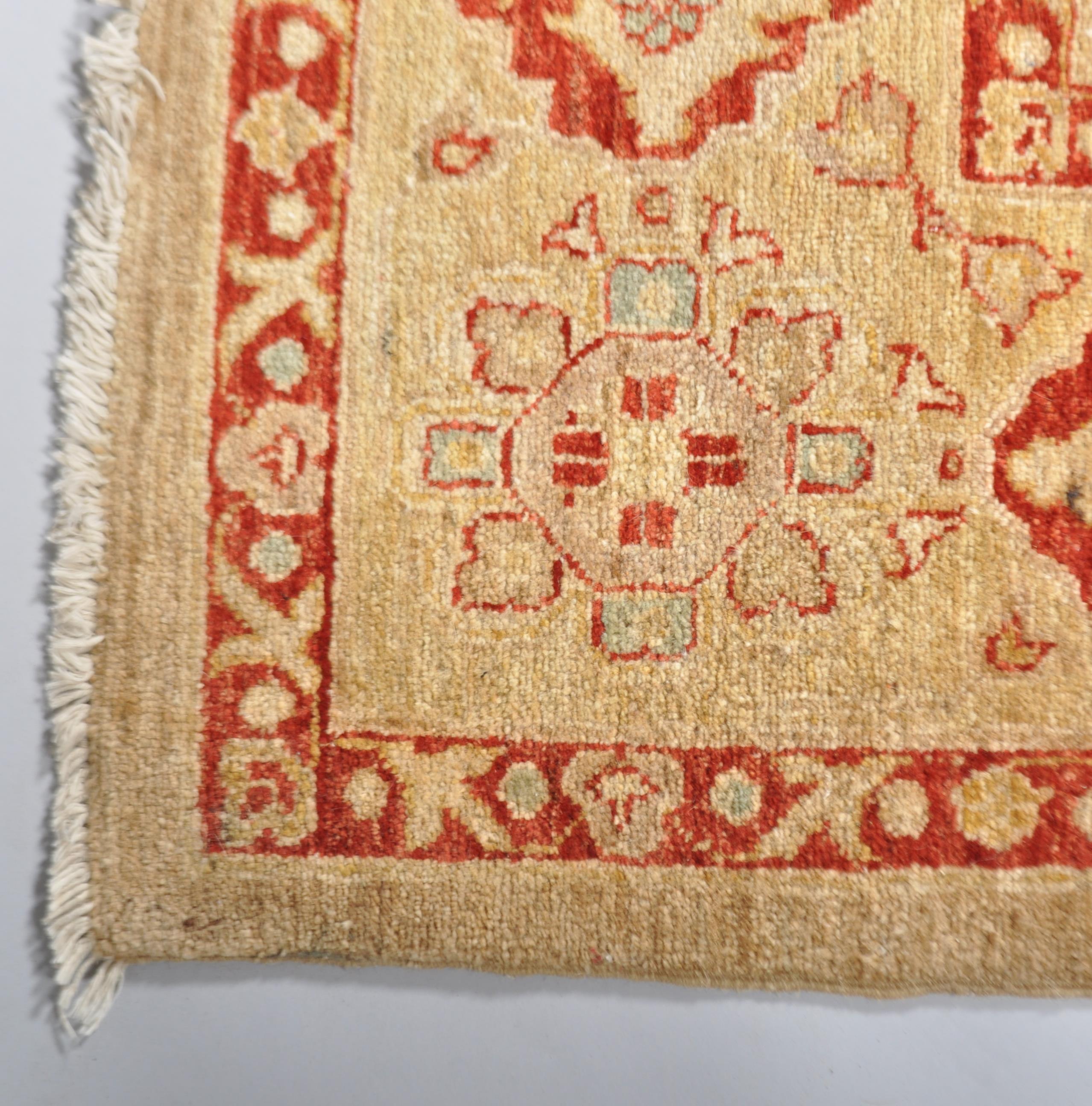 A wool carpet with pale brown ground woven with red jardinieres of flowers, - Image 2 of 3