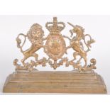 A brass fire surround mount cast with the Royal Arms, on a stepped plinth base,