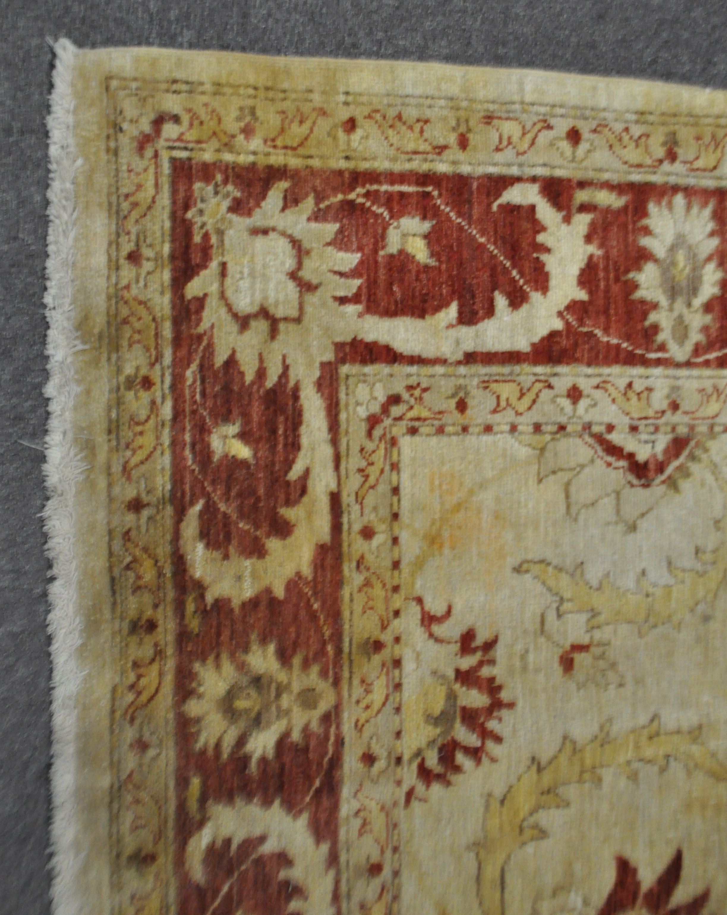 A wool carpet with beige ground woven with scrolling leaves and flowerheads in yellow, red and blue, - Image 2 of 3