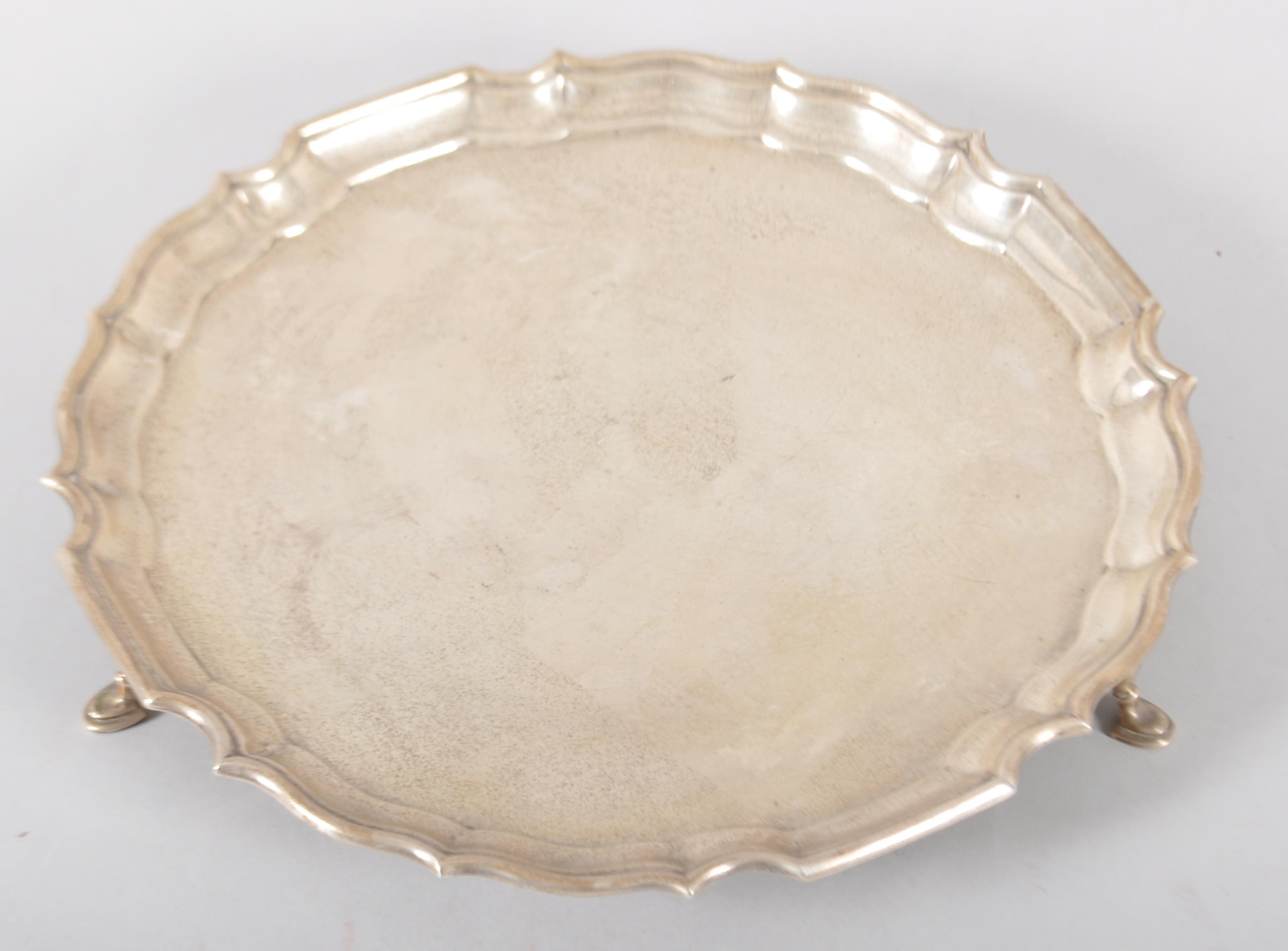 A silver salver, of plain form with Chipppendale border, raised on three pad feet, Sheffield 1966, - Image 7 of 7