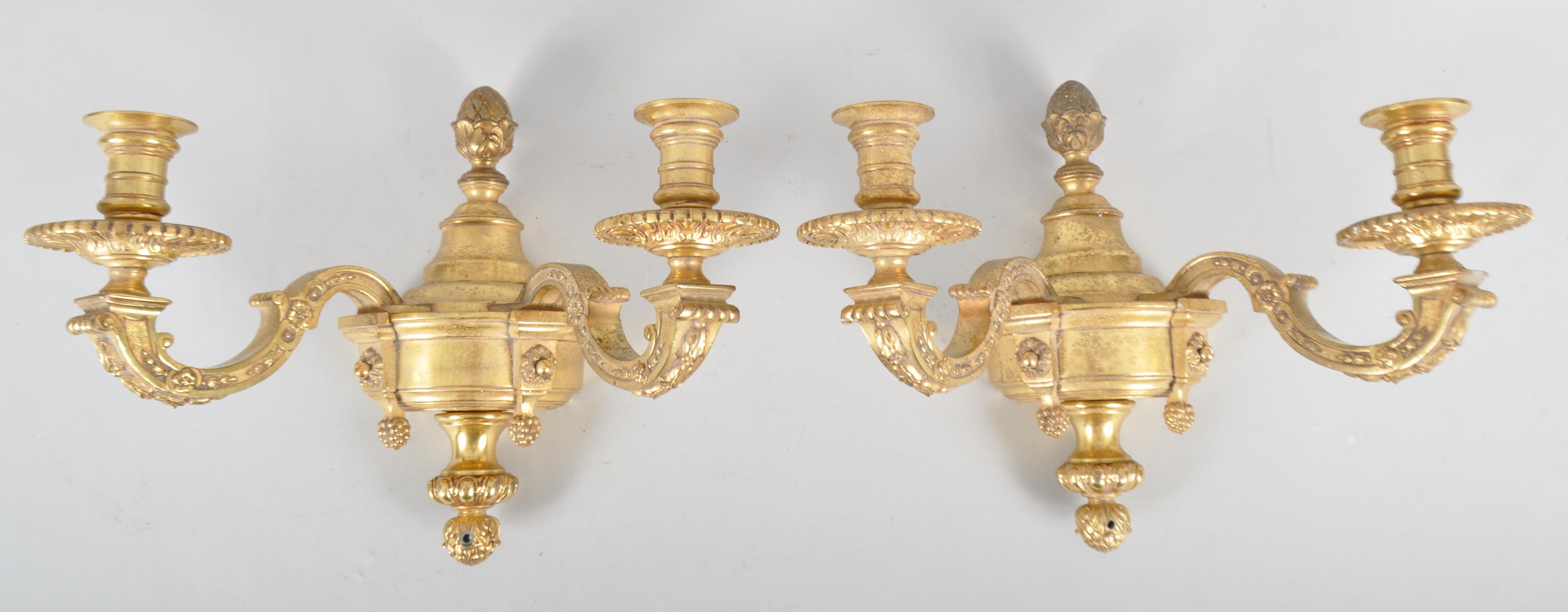 A pair of 20th century brass double wall sconce candlestick electric lights, in the Regence style,