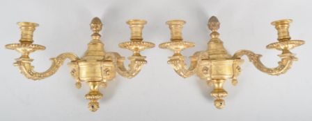 A pair of 20th century brass double wall sconce candlestick electric lights, in the Regence style,