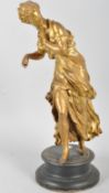 A gilt metal sculpture of a maiden, late 19th century, cast wearing a long flowing dress,
