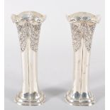 A pair of silver vases, of rounded squared shaped form, repousse decorated with swagged panels,