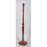 An early 20th century mahogany standard lamp, with turned and canted stem over hexagonal base,