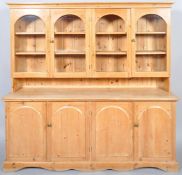 A contemporary pine glazed kitchen dresser with four arched rectangular glazed cupboards