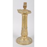 A Victorian brass lamp base, of column form cast with berried stiff leaves, acorns and medallions,