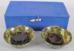 A pair of spinach jade bowls, each of flared form in mottled green hues,