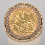 A yellow metal ring set with a half sovereign coin, dated 1905. Pierced shoulders with bark finish.